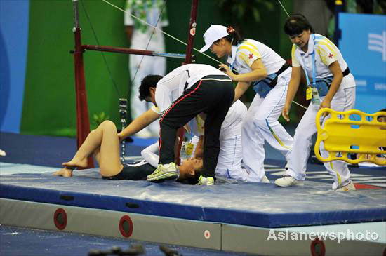 South Korean gymnast Jo Hyun-joo lies on the ground after falling off the uneven bars during the women's all-around final at the 26th Summer Universiade in Shenzhen, Aug 15, 2011. 