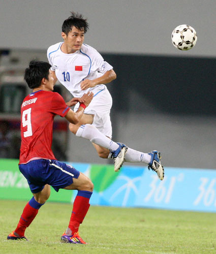 China's Yang Yang (top) heads the ball towards the goal in the team's group match against South Korea during the 26th Summer Universiade in Shenzhen, Aug 16, 2011. 