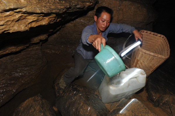 Wu Youzhi, a farmer in drought-hit Qinglong County, Guizhou Provincee, collects water in a cave early in the morning of Aug 17, 2011. 