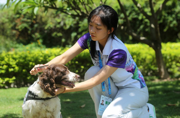 Serving as a security police officer at the Universiade, Gui Lin, a member of the criminal investigation team of the Beijing municipal public security bureau plays with her unlikely colleague, a dog named Lucky, in south China&apos;s Shenzhen City on August 14, 2011.
