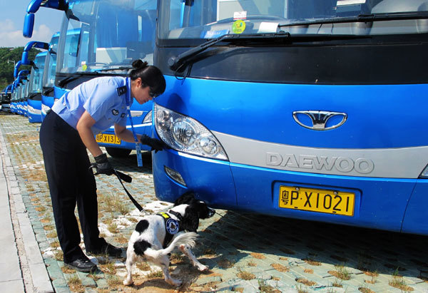 A security police officer of the Universiade, Yu Na, from the criminal investigation team of the Beijing municipal public security bureau, accompanies her canine colleague on a patrolling trip outside the venue in south China&apos;s Shenzhen City on August 14, 2011. 