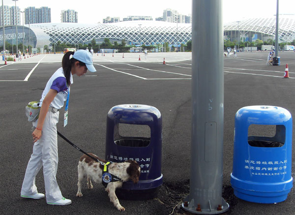 Gui Lin accompanies her canine colleague on a patrolling trip outside the venue in south China&apos;s Shenzhen City on August 14, 2011.
