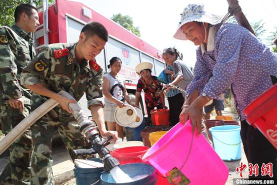 Villagers receive fresh water from the local fire brigade in Yongchuan District of Chongqing Municipality Aug. 17, 2011.