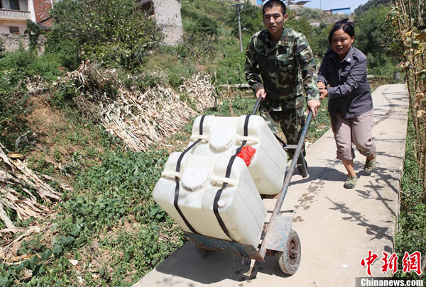 Villagers receive fresh water from the local fire brigade in Yongchuan District of Chongqing Municipality Aug. 17, 2011. 