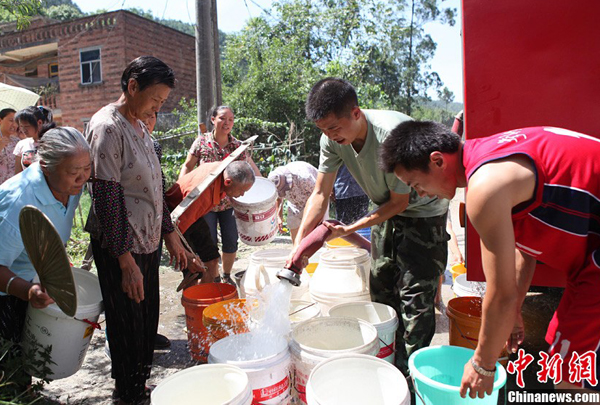 Villagers receive fresh water from the local fire brigade in Yongchuan District of Chongqing Municipality Aug. 17, 2011. 