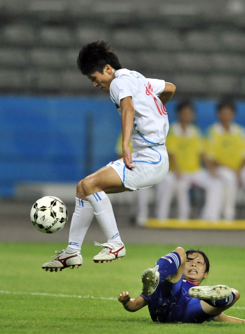 China&apos;s Wang Shanshan (top) controls the ball as she leaps over a Japanese player during the women&apos;s football final at the 26th Summer Universiade in Shenzhen August 21, 2011.