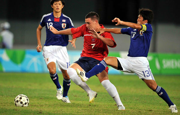 Moses Craig Peter (C) of Great Britain fights for the ball with Japanese players in the Universiade men's soccer finals at the Shenzhen Stadium in Shenzhen, Aug 22, 2011.