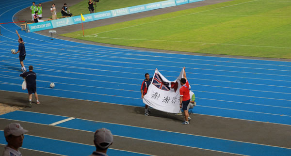 The British players demonstrate a banner reading 'Thank You Shenzhen' before the men's soccer finals against Japan at the 26th Summer Universiade in Shenzhen, Aug 22, 2011. 