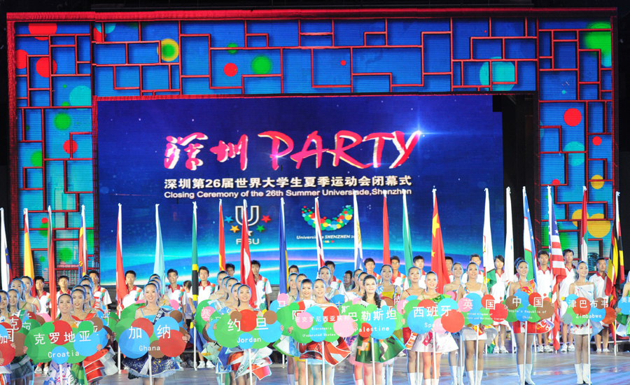 Girls hold name boards of delegations enter the site during the closing ceremony of the 26th Summer Universiade held at the Window of the World theme park in Shenzhen, a city of south China's Guangdong Province, Aug. 23, 2011. 