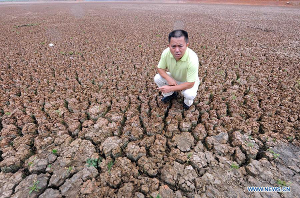 Wang Jun, an official in charge of local water management, shows the dried-up reservoir at Luliang County in Qujing City, southwest China's Yunnan Province, Aug. 23, 2011. 