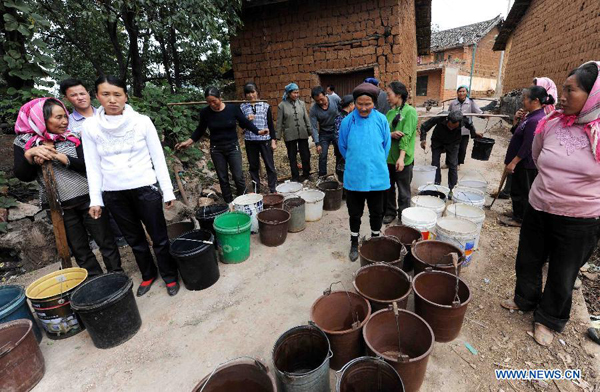 Villagers queue up for water delivered by a vehicle from a dozen kilometers away at the Qingshan Village of Zhanyi County in Qujing City, southwest China's Yunnan Province, Aug. 25, 2011.