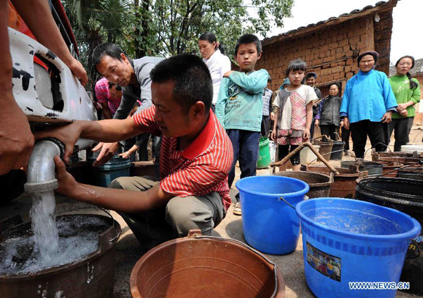 Villagers queue up for water delivered by a vehicle from a dozen kilometers away at the Qingshan Village of Zhanyi County in Qujing City, southwest China's Yunnan Province, Aug. 25, 2011. 