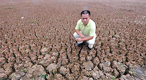 Wang Jun, an official in charge of local water management, shows the dried-up reservoir at Luliang County in Qujing City, southwest China's Yunnan Province, Aug. 23, 2011.