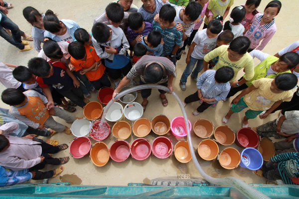 Water transported by a water wagon is allocated to students and teachers at Gengsha School in Fengshan County, south China&apos;s Guangxi Zhuang Autonomous Region, Sept 7, 2011. 