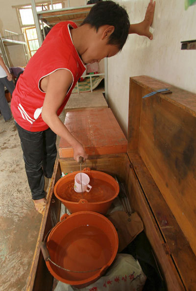 A student deposits his bucket of allocated water in a wooden trunk at Gengsha School in Fengshan County, south China&apos;s Guangxi Zhuang Autonomous Region, Sept 7, 2011. 