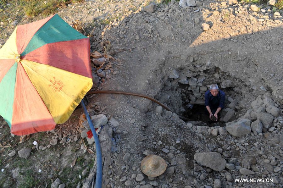 Meng Xiaode, a local villager, digs a water well for irrigation in the field in Pingman Village of Tianlin County, south China&apos;s Guangxi Zhuang Autonomous Region, Sept. 7, 2011. 