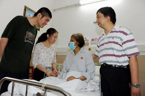 Peng Si and his twin sister (L2) comfort their mother, who survived organ transplant surgery during which part of her son&apos;s liver was transplanted to her, at a hospital in Guangzhou, south China&apos;s Guangdong Province on Sep 10, 2011.