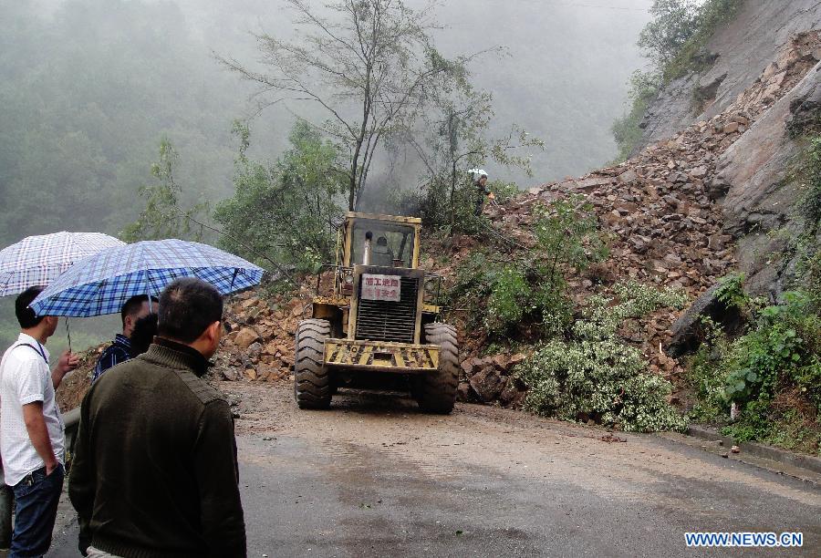 Heavy equipments are seen working to clear up the road blocked by landslides in Qinghua Township of Wanyuan, southwest China&apos;s Sichuan Province, Sept. 14, 2011. 