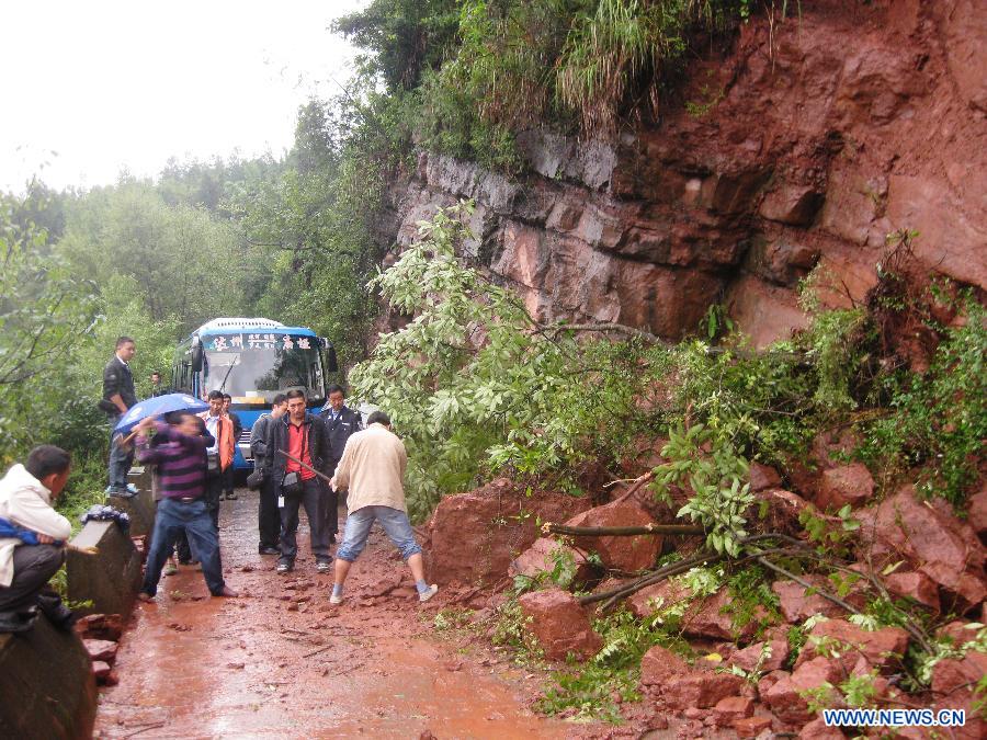 People try to clear up the road blocked by landslides in Qinghua Township of Wanyuan, southwest China&apos;s Sichuan Province, Sept. 13, 2011. 