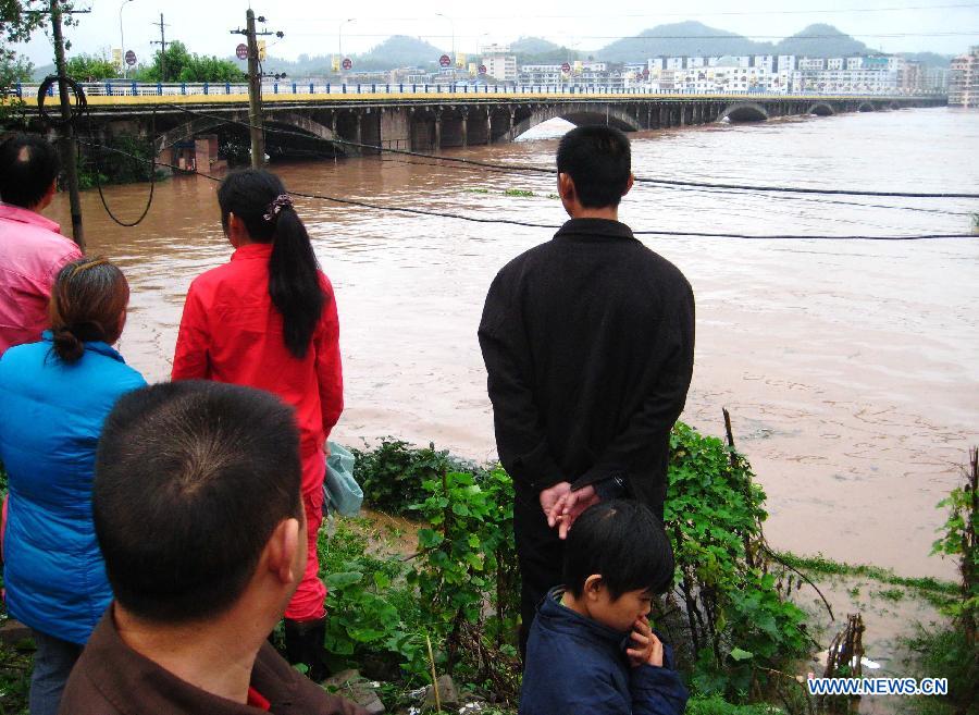 Residents look on rising waters in Quxian County, southwest China&apos;s Sichuan Province, Sept. 19, 2011.