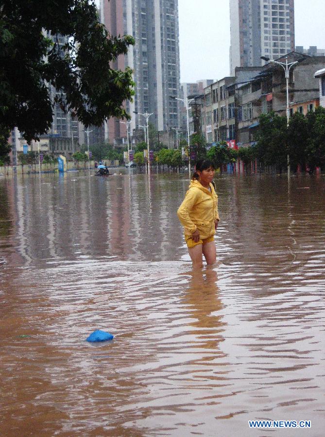 A woman wades through floodwaters in Quxian County, southwest China&apos;s Sichuan Province, Sept. 19, 2011. 