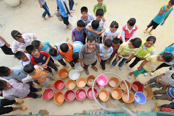 Students at Gengsha School in Fengshan County of Hechi City, in Guangxi Zhuang Autonomous Region, wait for drinking water on Sept 19, 2011.