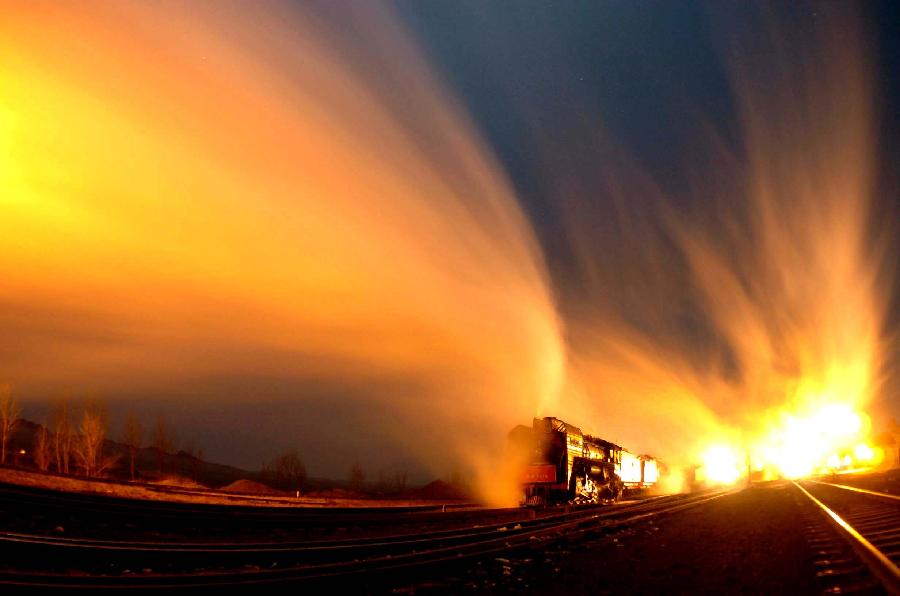 File photo taken on Dec. 24, 2004 shows a steam engine train rolls in the Hexigten Banner, north China&apos;s Inner Mongolia Autonomous Region. 