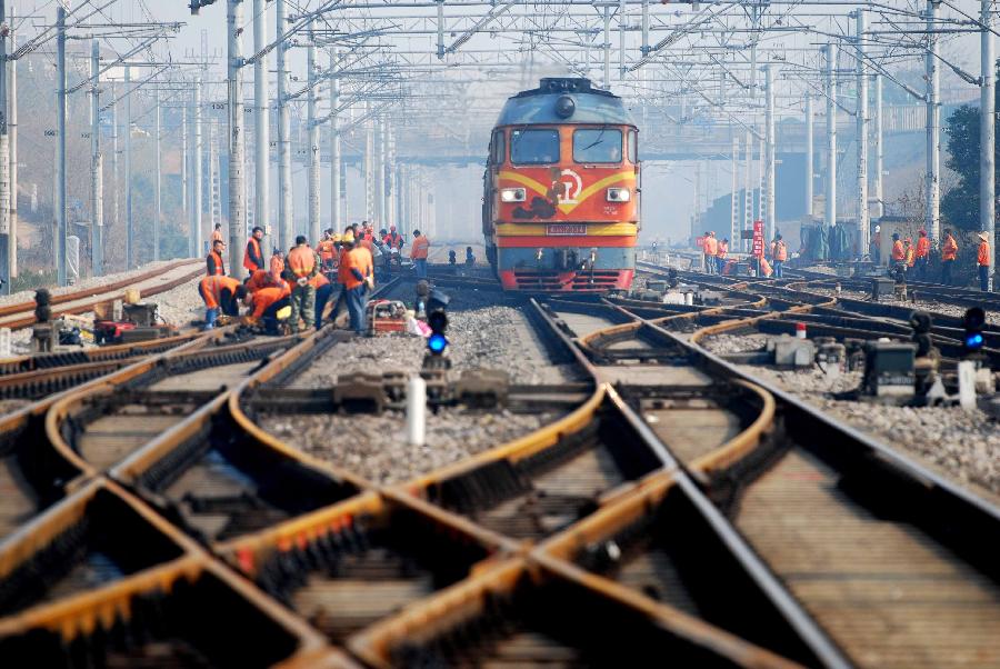 File photo taken on Dec. 20, 2010 shows maintenance workers examine and repair a section of the Beijing-Kowloon Railway near the Jiujiang Railway Station of east China&apos;s Jiangxi Province.