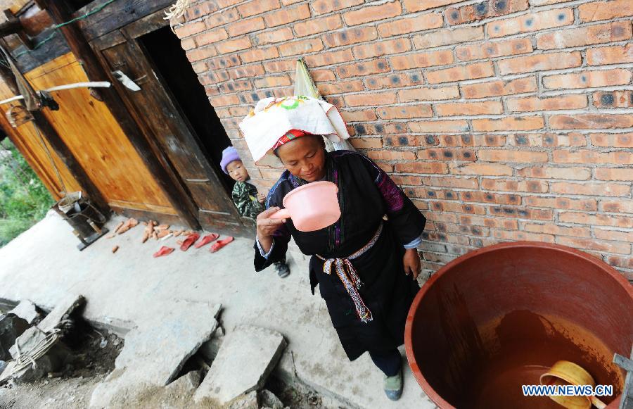 A villager bails water to drink from her water vat at Guisa village in Zhenyuan County, southwest China&apos;s Guizhou Province, Sept. 23, 2011. 