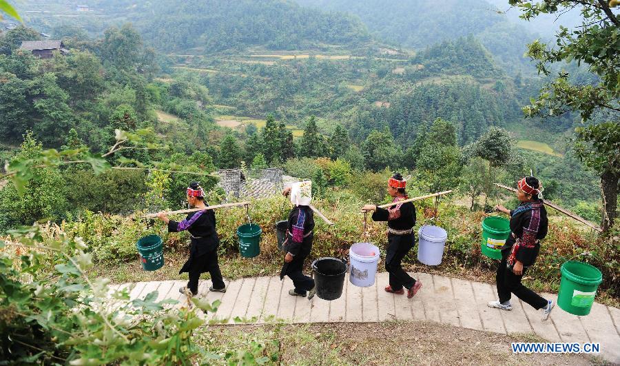 People return home with water at Guisa village in Zhenyuan County, southwest China&apos;s Guizhou Province, Sept. 23, 2011. 