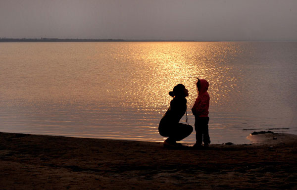 Photo taken on Sept 24, 2011 shows tourists beside China&apos;s largest desert lake Hongjiannao in Yulin, north China&apos;s Shaanx Province.