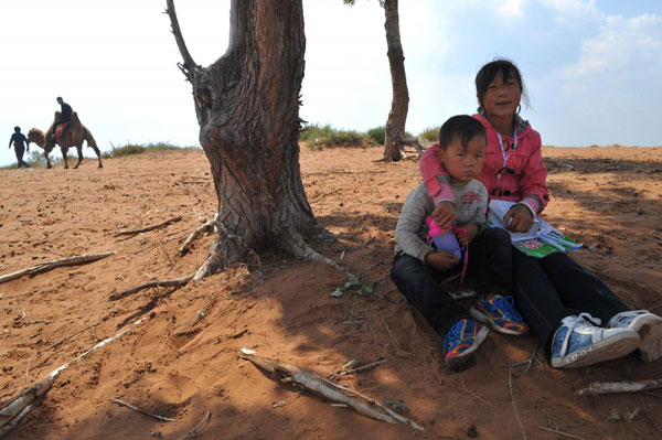 Photo taken on Sept 24, 2011 shows Liujia and her brother, villagers living around China&apos;s largest desert lake Hongjiannao, in Yulin, north China&apos;s Shaanx Province.