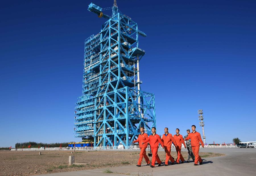 Staff workers march to a department to inject fuel for the Long March-2FT1 carrier rocket at the Jiuquan Satellite Launch Center in northwest China&apos;s Gansu Province, Sept. 28, 2011. 