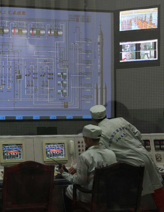 Technicians work to adjust electronic devices at the Jiuquan Satellite Launch Center in northwest China&apos;s Gansu Province, Sept. 28, 2011. 