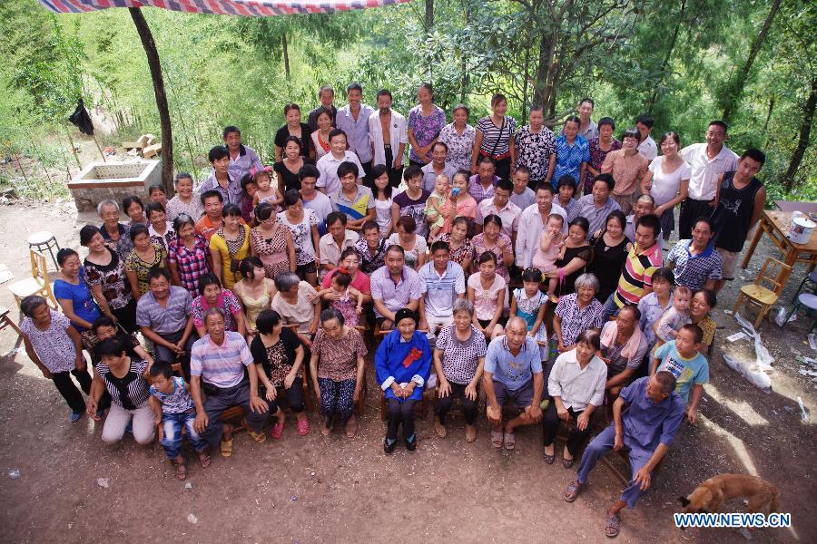 The file photo taken on Aug. 20, 2011 shows centenarian Zhang Dengke (C, first row) taking a group photo with her entire family in Zigui County of central China&apos;s Hubei Province.