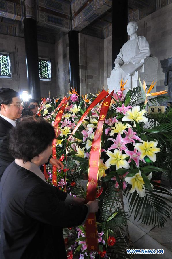 People lay flower baskets for the sculpture of Dr. Sun Yat-Sen, at the mausoleum of Dr. Sun Yat-sen in Nanjing, capital of east China&apos;s Jiangsu Province, Oct. 10, 2011.