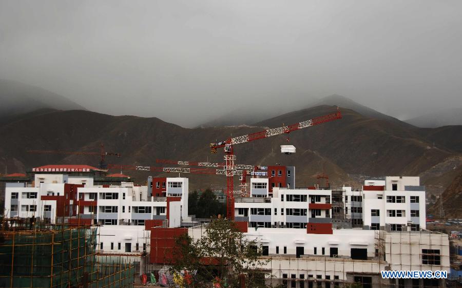Photo taken on Sept. 29, 2011 shows residential houses under construction in Yushu, northwest China&apos;s Qinghai Province. 