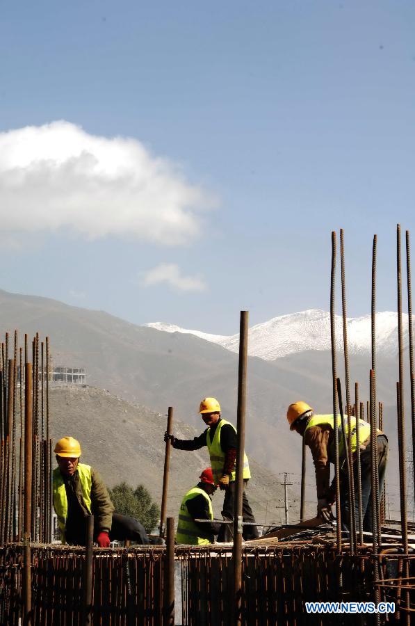 Workers devote themselves to the reconstruction in Yushu, northwest China&apos;s Qinghai Province, Oct. 6, 2011.