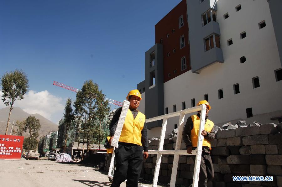 Two workers move a window frame in a construction site in Yushu, northwest China&apos;s Qinghai Province, Oct. 6, 2011.