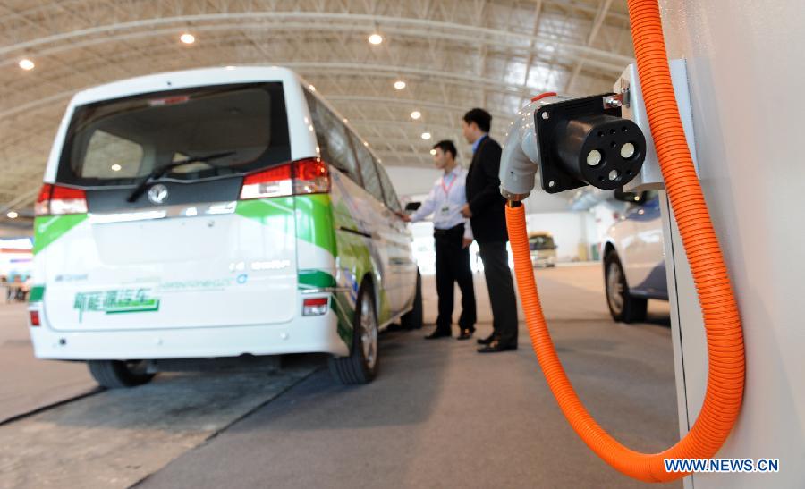 A visitor looks at a battery-driven vehicle during the 2011 China International New Energy Vehicles Industry Promotion Week in Beijing, capital of China, Oct. 13, 2011. 