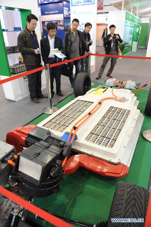 Visitors view a set of energy system of a battery-driven vehicle during the 2011 China International New Energy Vehicles Industry Promotion Week in Beijing, capital of China, Oct. 13, 2011. 