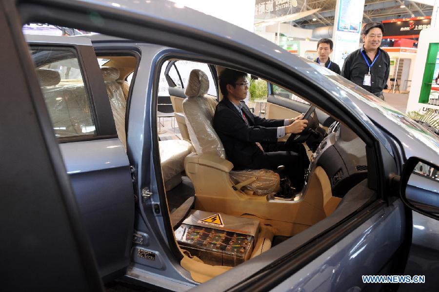 A visitor tries a battery-driven vehicle during the 2011 China International New Energy Vehicles Industry Promotion Week in Beijing, capital of China, Oct. 13, 2011.