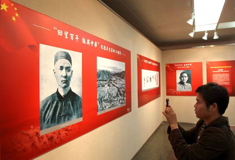 A visitor takes photos of the pictures at a photo show to commemorate the 100th anniversary of the 1911 (Xinhai) Revolution in Shanghai, east China, Oct. 19, 2011. The photo show displayed over 200 pictures related to the 1911 Revolution.