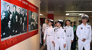 Navy sailors watch a photo show to commemorate the 100th anniversary of the 1911 (Xinhai) Revolution in Shanghai, east China, Oct. 19, 2011.