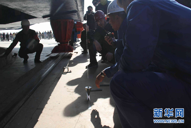 Workers test the Shenzhou VIII Spacecraft and assembled Long March II-F rocket prior to launch.