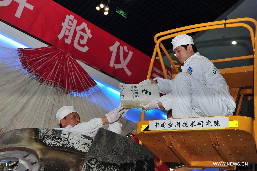 Researchers retrieve items on board the re-entry capsule of China&apos;s unmanned spacecraft Shenzhou-8 in Beijing, capital of China, Nov. 21, 2011. 