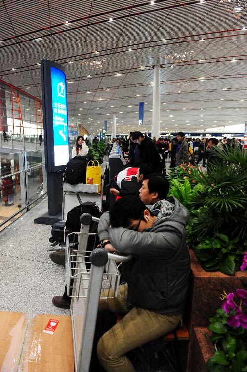 Passengers wait to board their flights at Capital International Airport in Beijing, capital of China, Dec. 5, 2011.