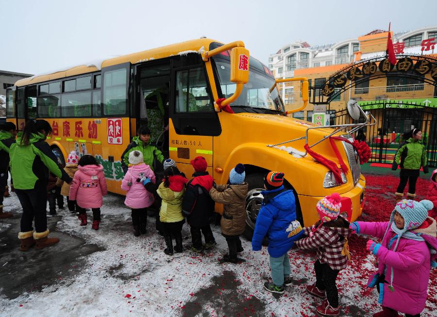 Children queue up to take on an American-style school bus of a kindergarten in Fushan District, Yantai City, east China&apos;s Shandong Province, Dec. 10, 2011. 