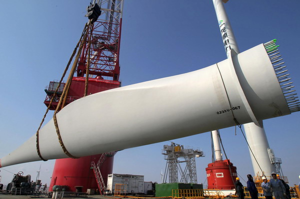 Part of a wind turbine is hoisted at an offshore plant in Rudong County, east China&apos;s Jiangsu Province, Dec 27, 2011. 