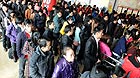Passengers queue up to buy tickets at the coach station at Luocheng County in south China's Guangxi Zhuang Autonomous Region, Jan. 26, 2012. China is braced for a new travel rush, as millions of travelers are returning to city work near the end of the week-long Spring Festival holiday.